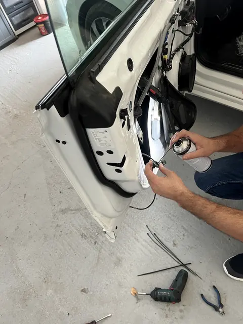 Tehnician lucrând la ușa demontată a unui autoturism
